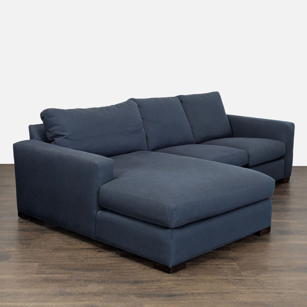 Spacious sectional sofa in dark blue fabric by Room and Board, offering clean lines and plush cushions.