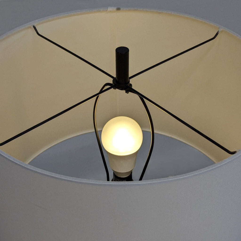 Target wood tripod floor lamp featuring a white shade and round shelf, perfect for cozy, stylish spaces.