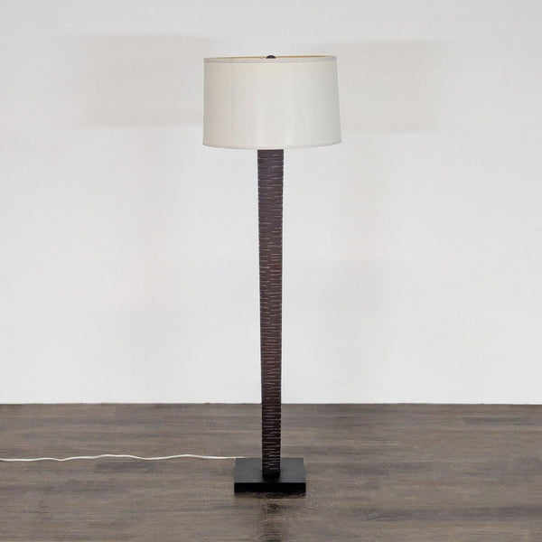 Modern floor lamp with dark wood base and white drum shade, suitable for contemporary interiors.  