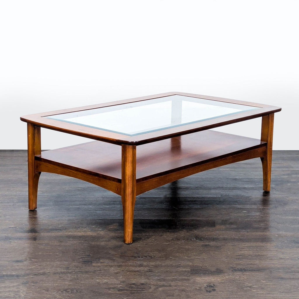 Rectangular Riverside Furniture coffee table with dual glass shelves and sleek beveled edges.