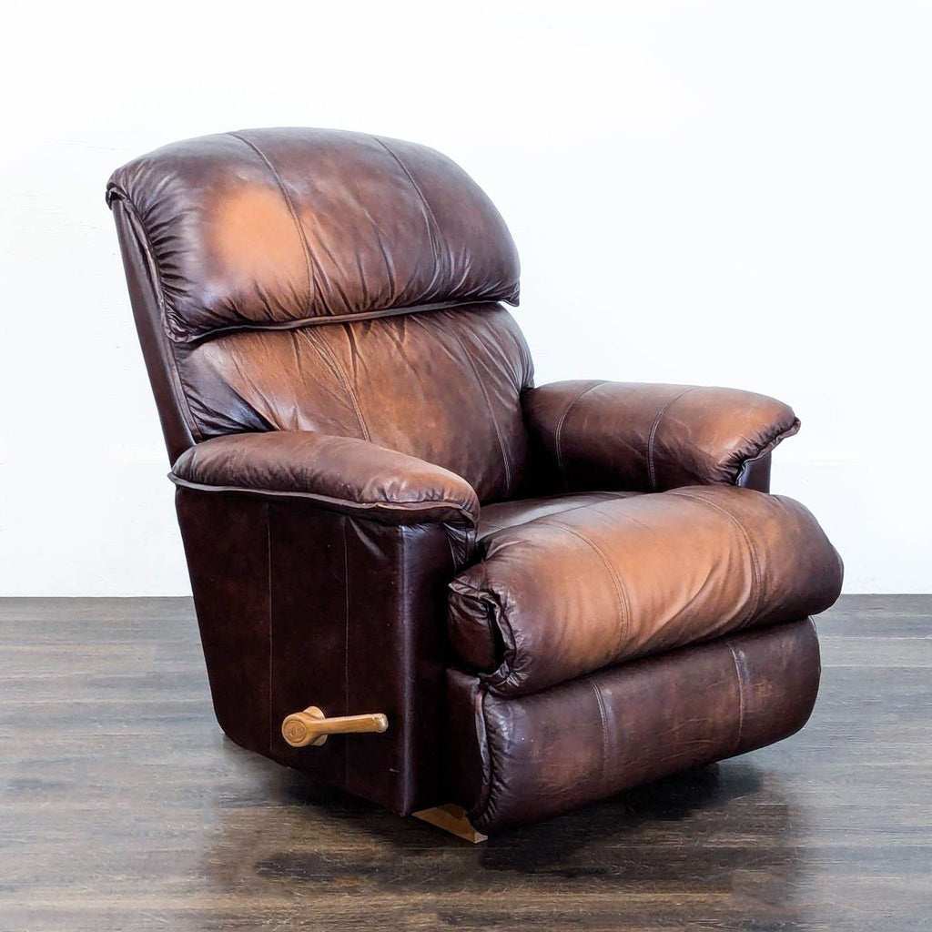 2. Angled side view of a brown leather La-Z-Boy recliner chair featuring a wooden lever and soft armrests.
