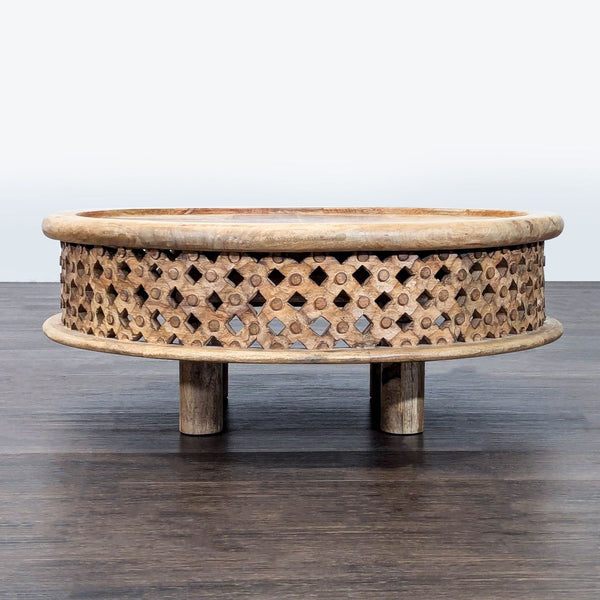 West Elm coffee table of solid mango wood with a hand-carved rosette pattern and natural wood grain.