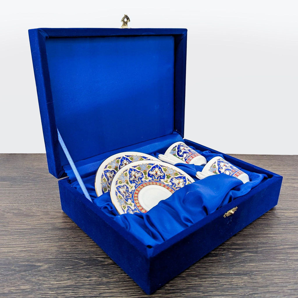 Two porcelain cups and saucers with ornate blue and gold details in a luxurious blue box, ideal for gifting.