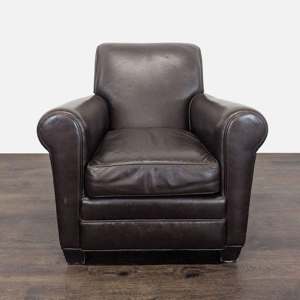 Dark brown leather lounge chair with cushioned seat, rolled arms, and minor wear, ideal for relaxation.