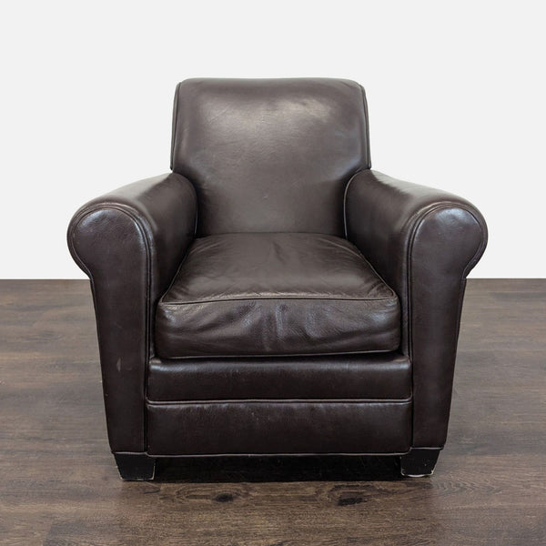 Dark brown leather lounge chair with cushioned seat, rolled arms, and minor wear, ideal for relaxation.
