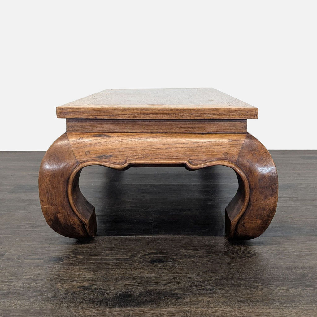2. Close-up side view of a wooden coffee table, highlighting its distinctive curved leg design.