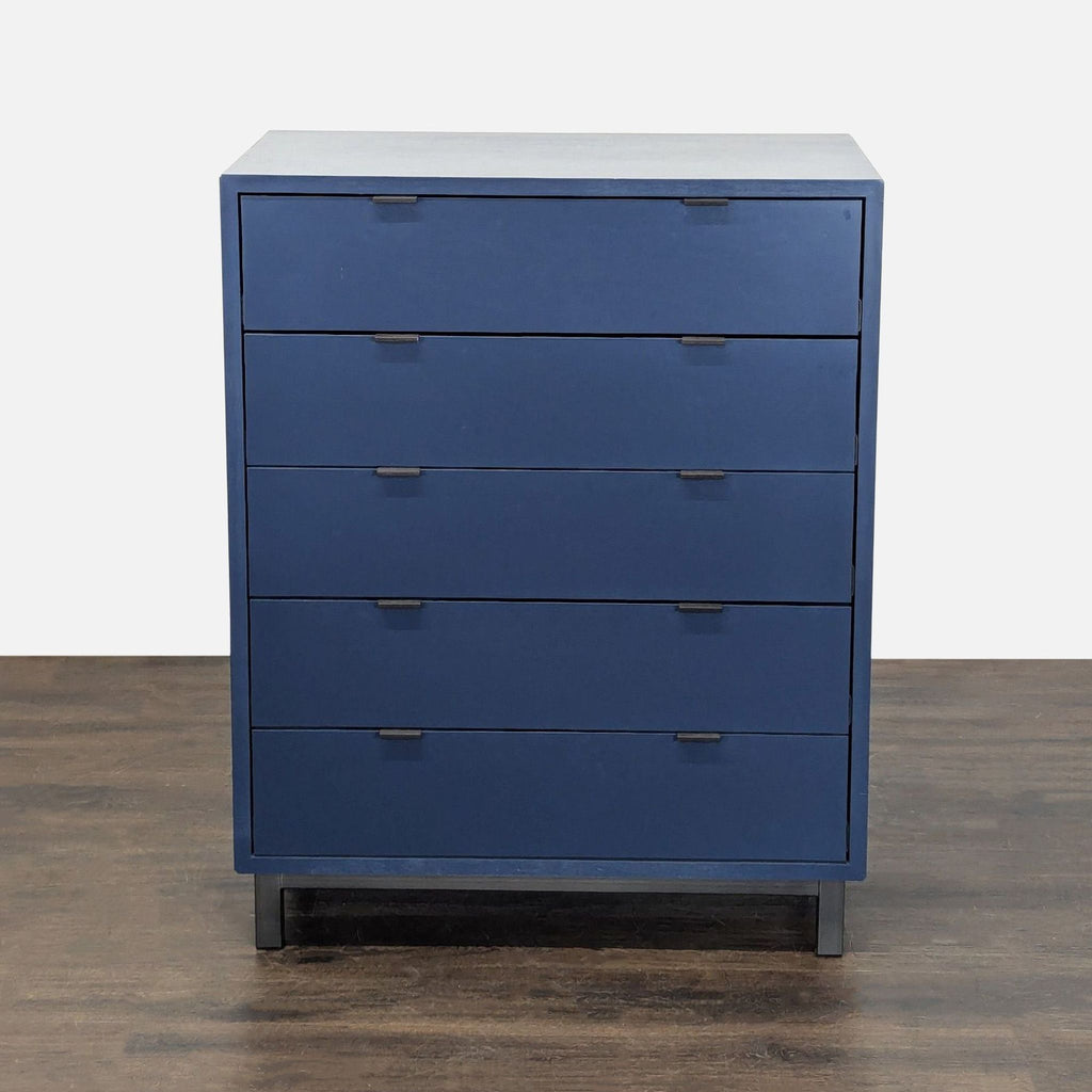 Modern blue Room & Board dresser with five drawers, sleek lines, and easy-pull handles for bedroom storage.