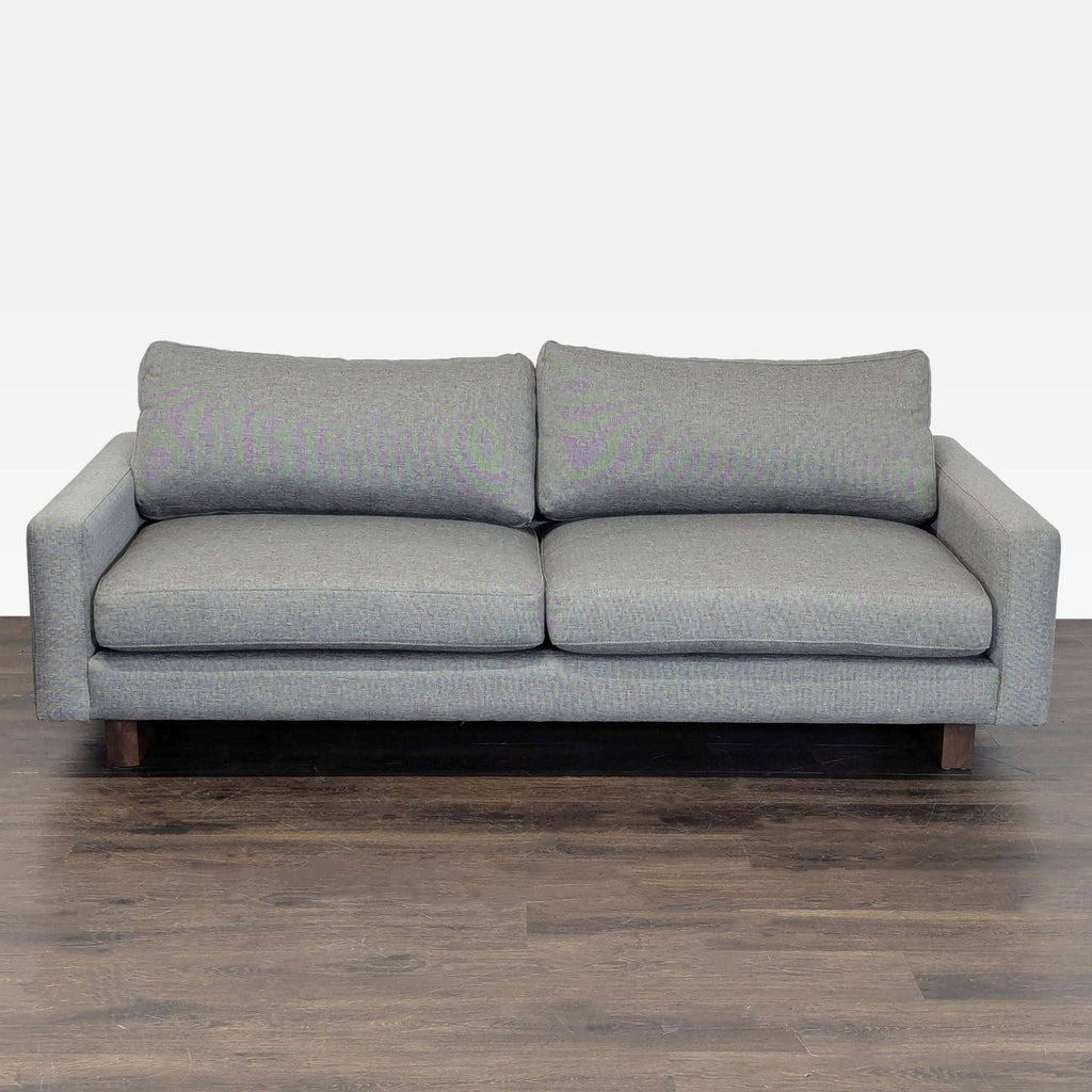 Gray Room & Board loveseat with plush cushions and wooden legs, ideal for modern living rooms or offices.