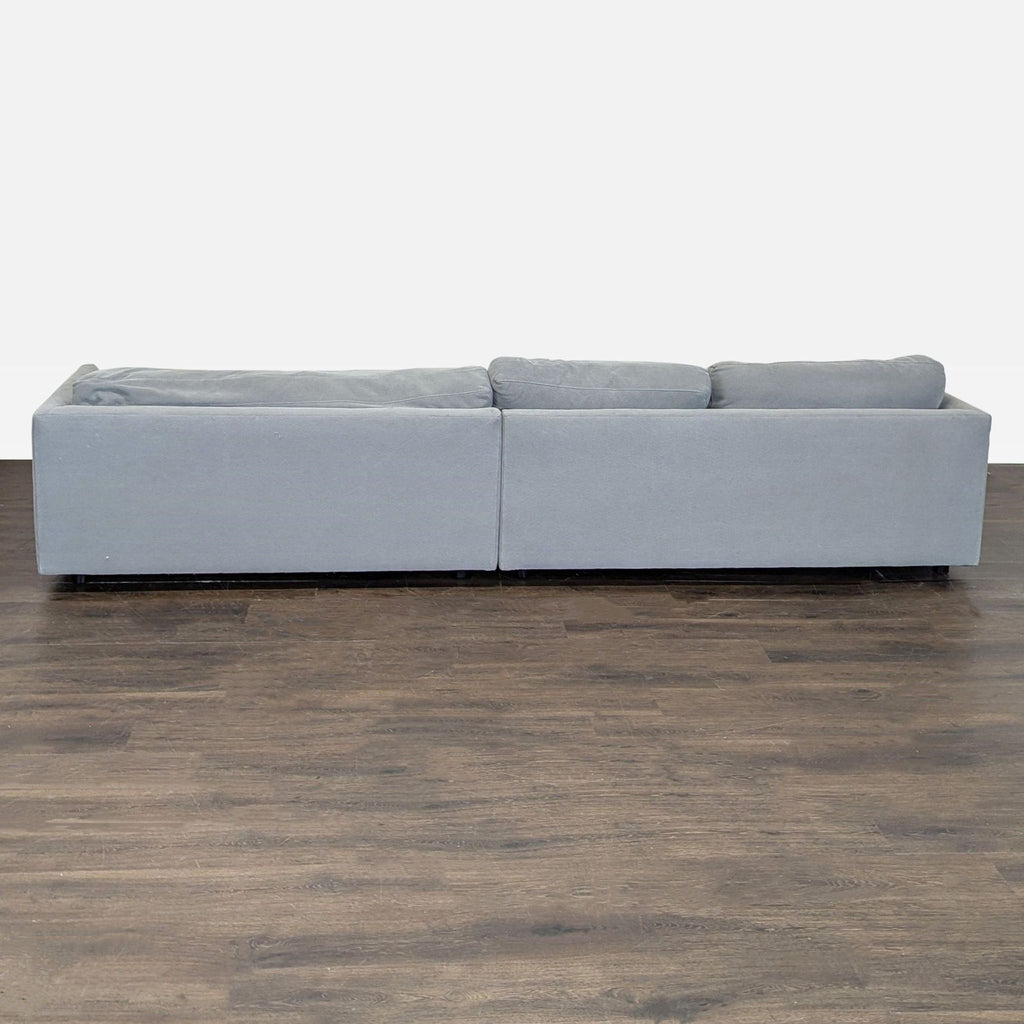 Sectional by West Elm in soft gray upholstery with clean lines and plush comfort, seating multiple people.