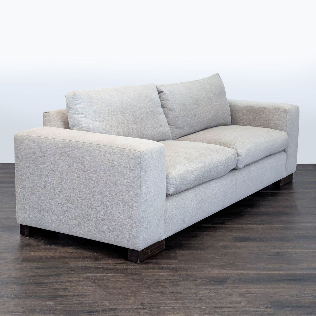 2. Angled side view of a Kreiss Loveseat, highlighting plush cushions and modern, boxy design.  