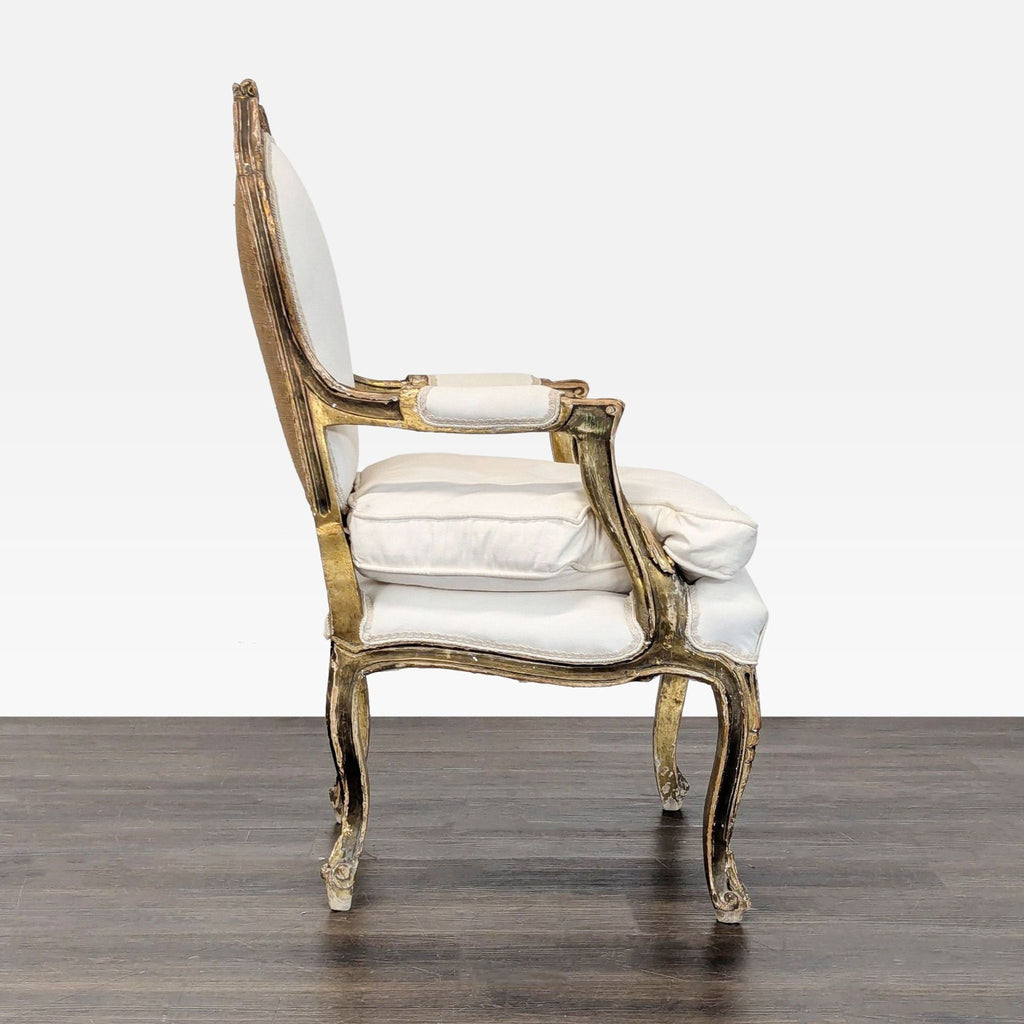 Classic white-upholstered armchair with ornate gold wood trim, curved legs, and decorative carvings.  