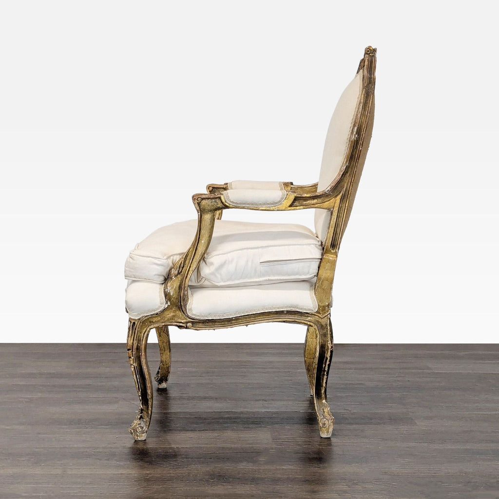 Ornate vintage chair with cushioned white seat, gold detailing, and sophisticated carved wood design.