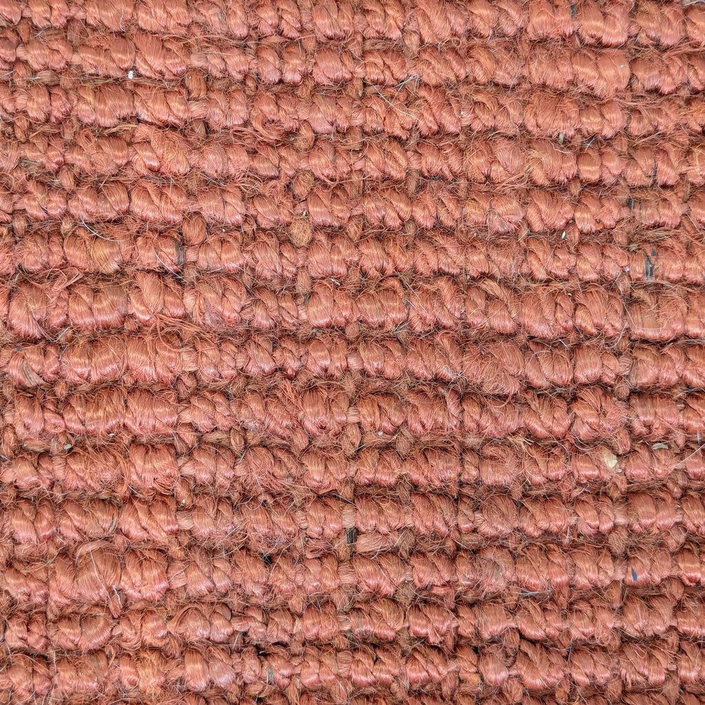 2. Close-up of the West Elm jute rug reveals its textured weave and warm rust-colored fibers.  