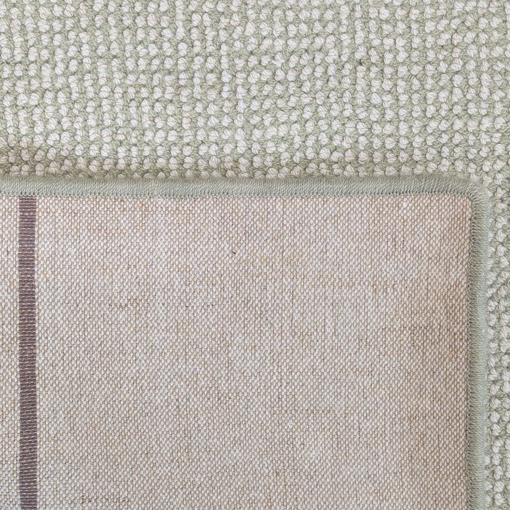 Versatile woven rug in a light, solid color, ideal for living rooms, bedrooms, or office use.