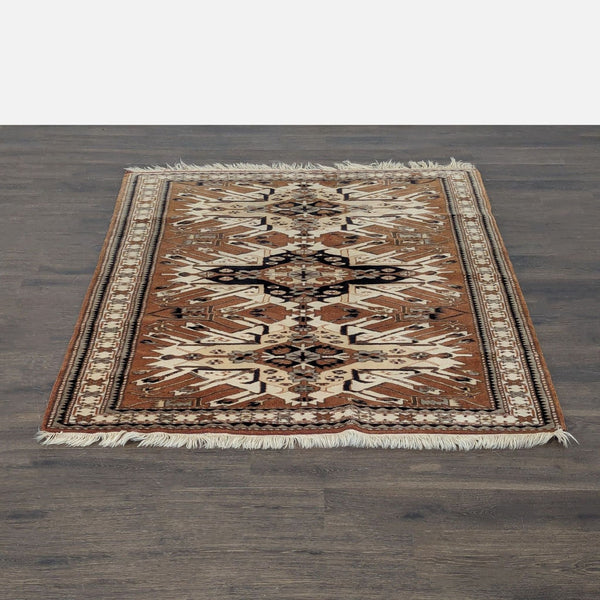 Geometric patterned rug in browns, beige, and black with fringed edges, shown on a living room floor.