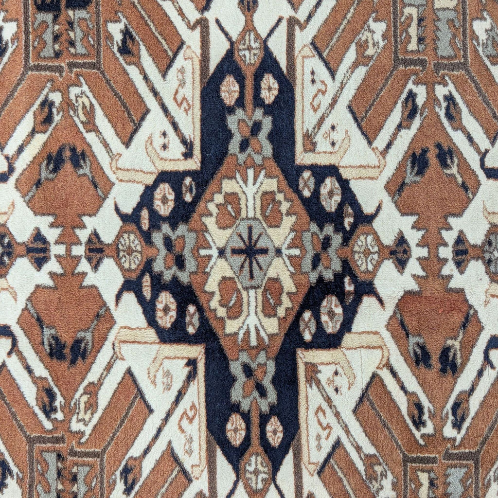 Area rug displaying an elegant, intricate geometric design in warm tones, finished with classic fringes.