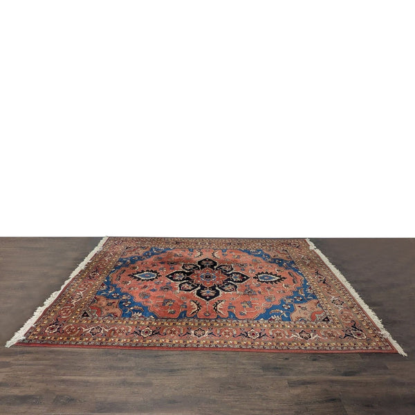 Persian-style rug with red, blue, and black medallion design and intricate floral patterns, finished with fringe.