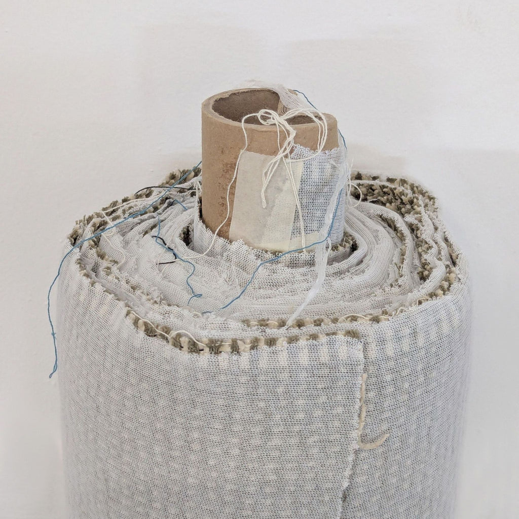 Textured roll of upholstery fabric in a neutral shade, categorized as Miscellaneous.