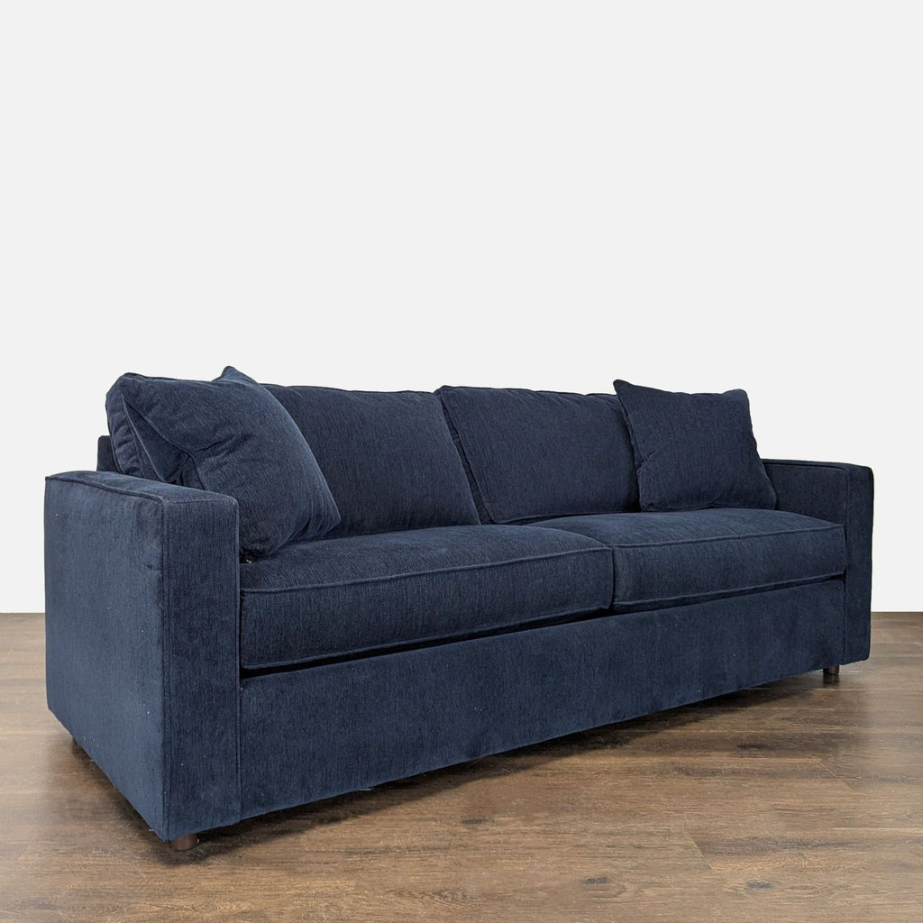 Three-seat navy sleeper sofa with a sleek design, matching pillows, and practical pull-out guest bed.
