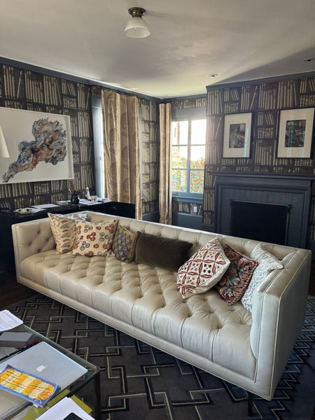 1. Cream tufted 3-seat leather sofa by Elite Leather Company, accented with patterned pillows in a stylish library room.