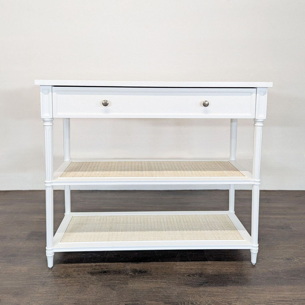 Solid hardwood table with turned columns, panel drawer, and woven cane shelves by Serena & Lily.  