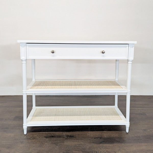 Solid hardwood table with turned columns, panel drawer, and woven cane shelves by Serena & Lily.  