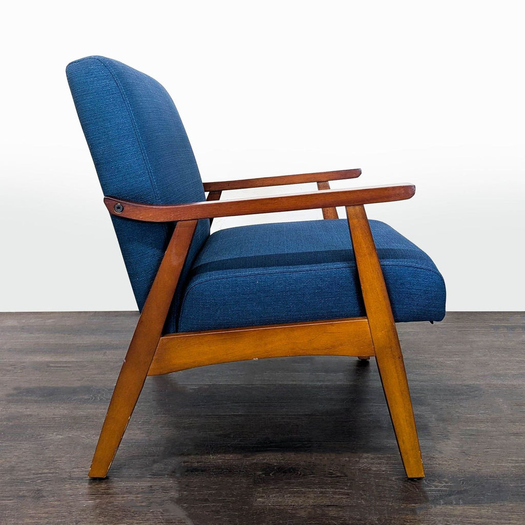 Modern blue fabric lounge chair with wooden structure, perfect for living rooms, offices, or reading nooks.