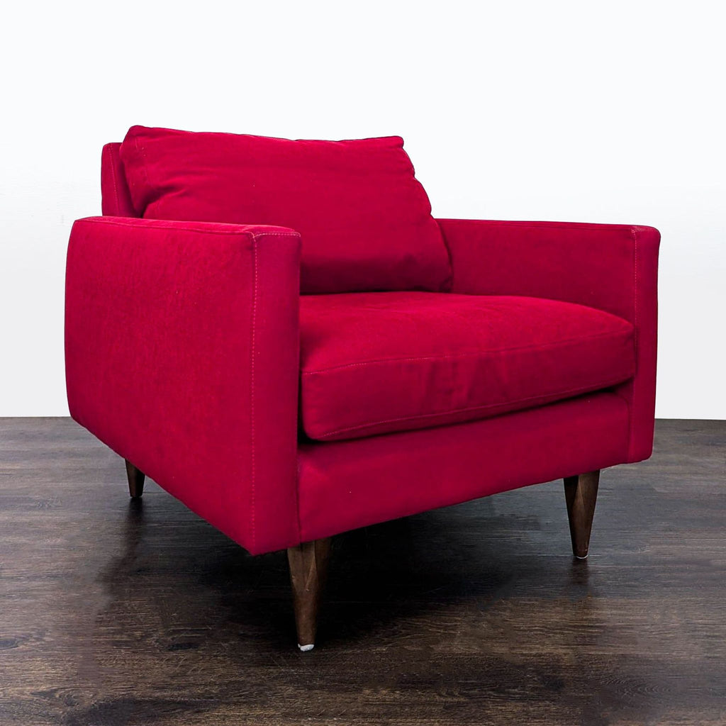 Modern red Room & Board lounge chair, featuring plush cushions and sturdy wooden legs.