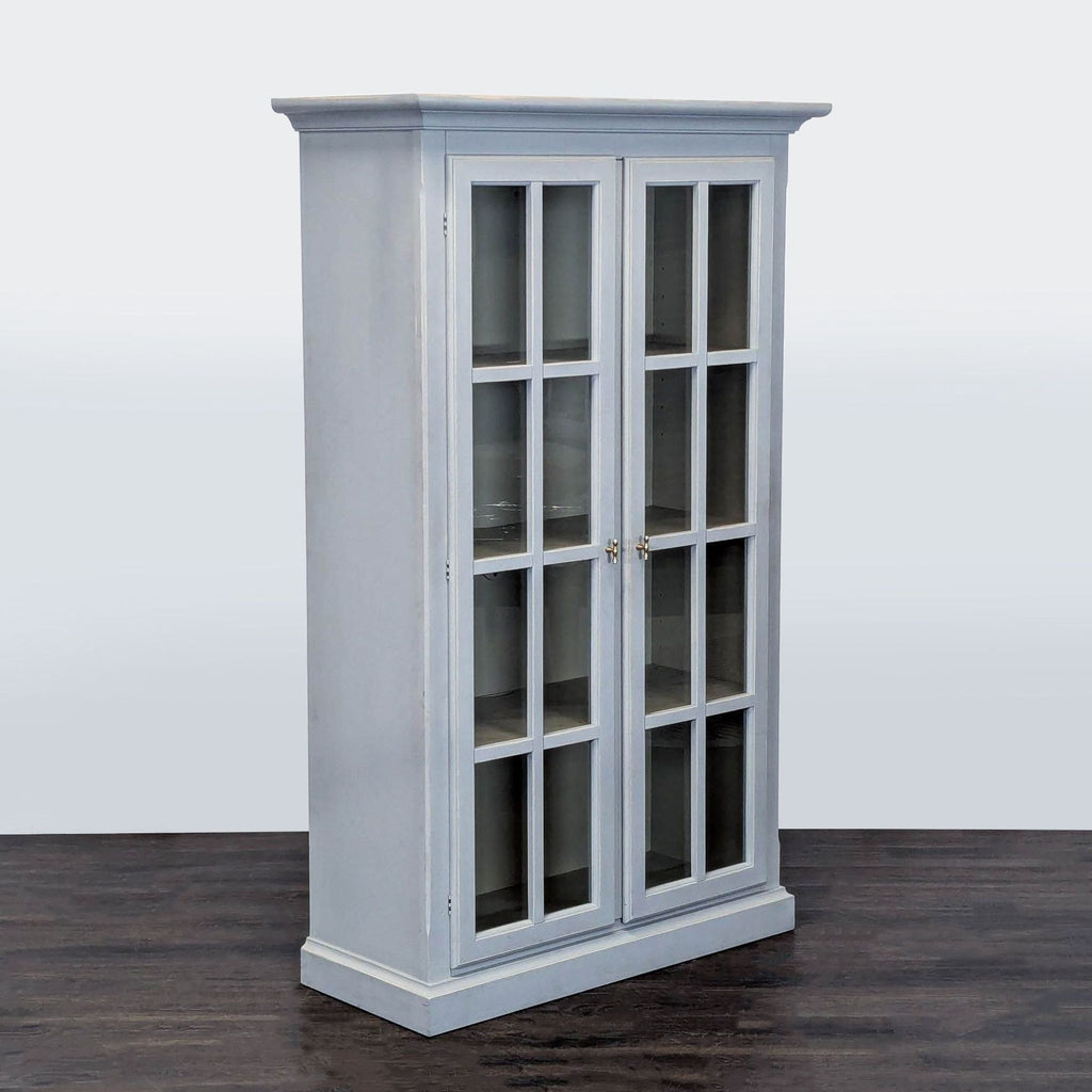 Crate & Barrel glass-door bookshelf in a clean gray design, ideal for organizing books or showcasing decor.