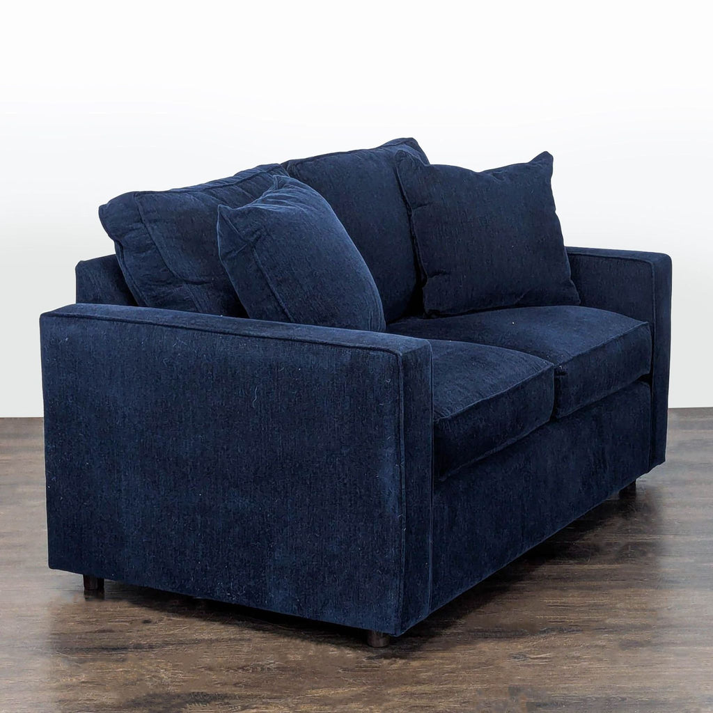Modern navy loveseat by Room and Board, featuring supportive armrests and plush seating for two.