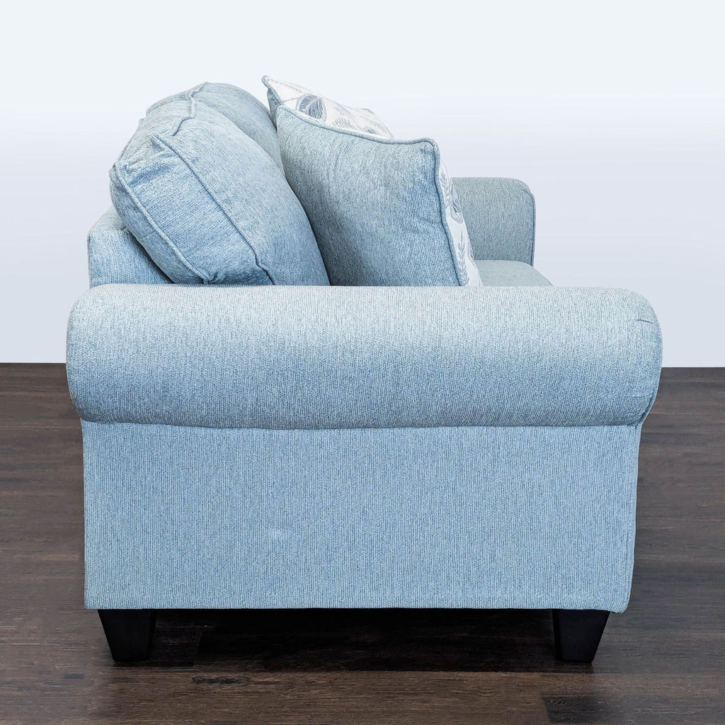 Cozy light blue loveseat by Minhaus with plush seat, rolled arms, leaf print pillows, and dark modern legs.