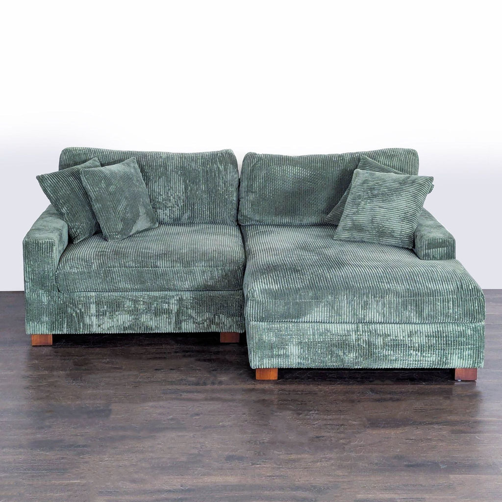 Green L-shaped Uixe sectional sofa with square arms, faux rabbit fur upholstery, and four matching pillows.