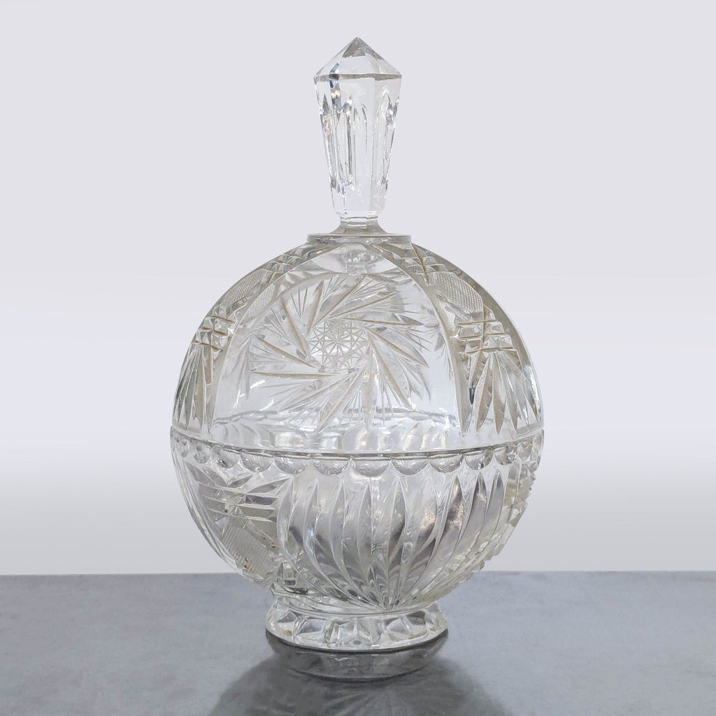 Vintage cut glass crystal bowl with lid on pedestal base, displaying elegant patterns; ideal for serving treats.