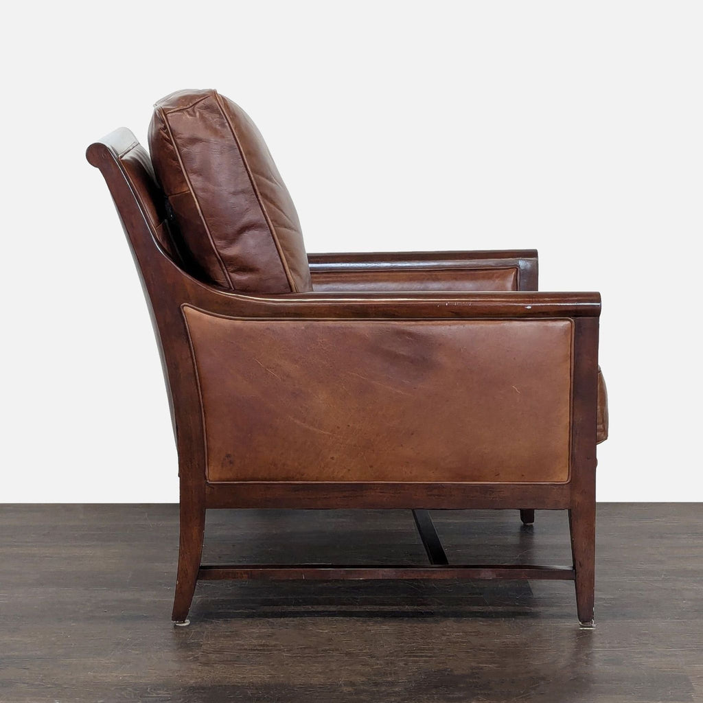Classic lounge chair with comfortable brown leather seat and backrest on a robust wood frame for relaxation.