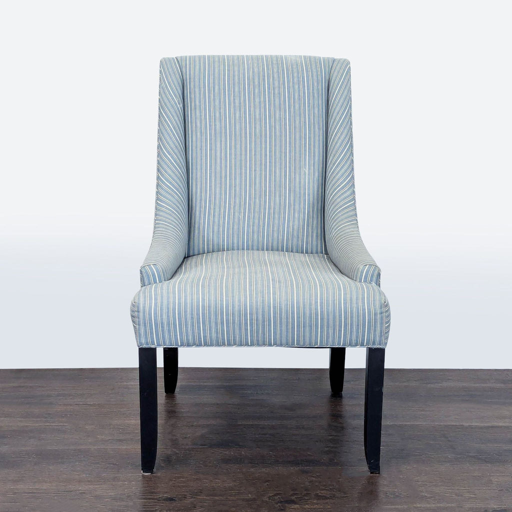 Blue and white striped lounge chair with padded seat, tall back, and dark wooden legs for modern comfort.  