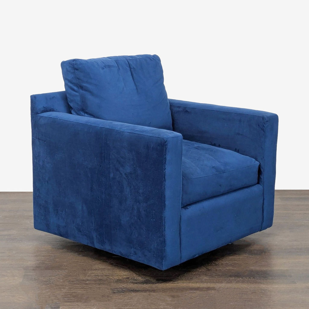 Cozy Crate & Barrel lounge chair in rich blue velvet, featuring a swivel base and supportive armrests.