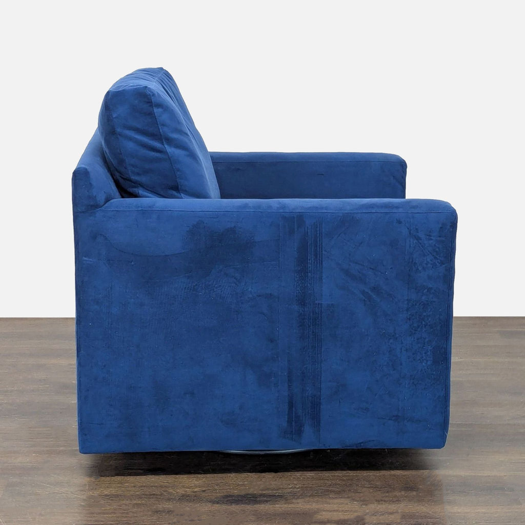 Modern lounge chair by Crate & Barrel, upholstered in blue velvet with soft seat, sturdy frame, and swivel design.