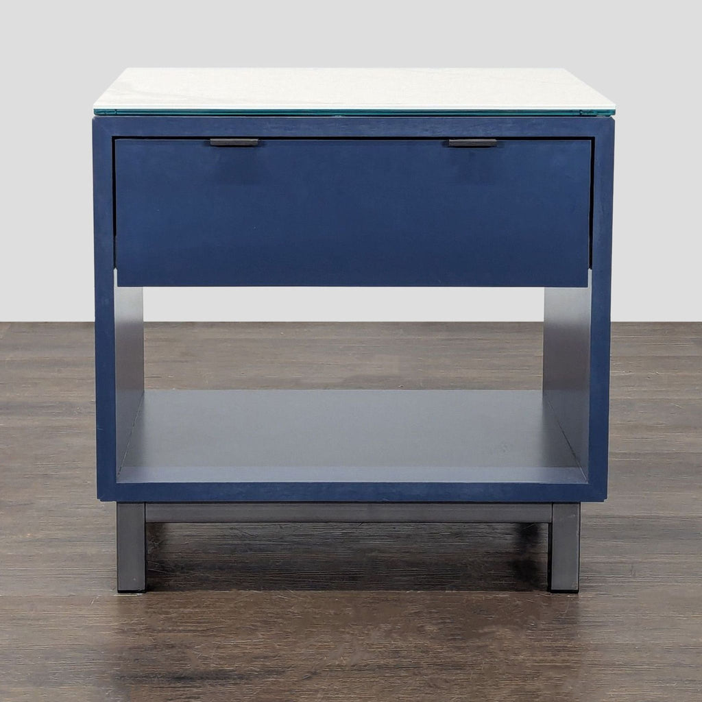 Navy Room & Board nightstand with marbled white ceramic top, open shelf, one drawer, and steel base.  