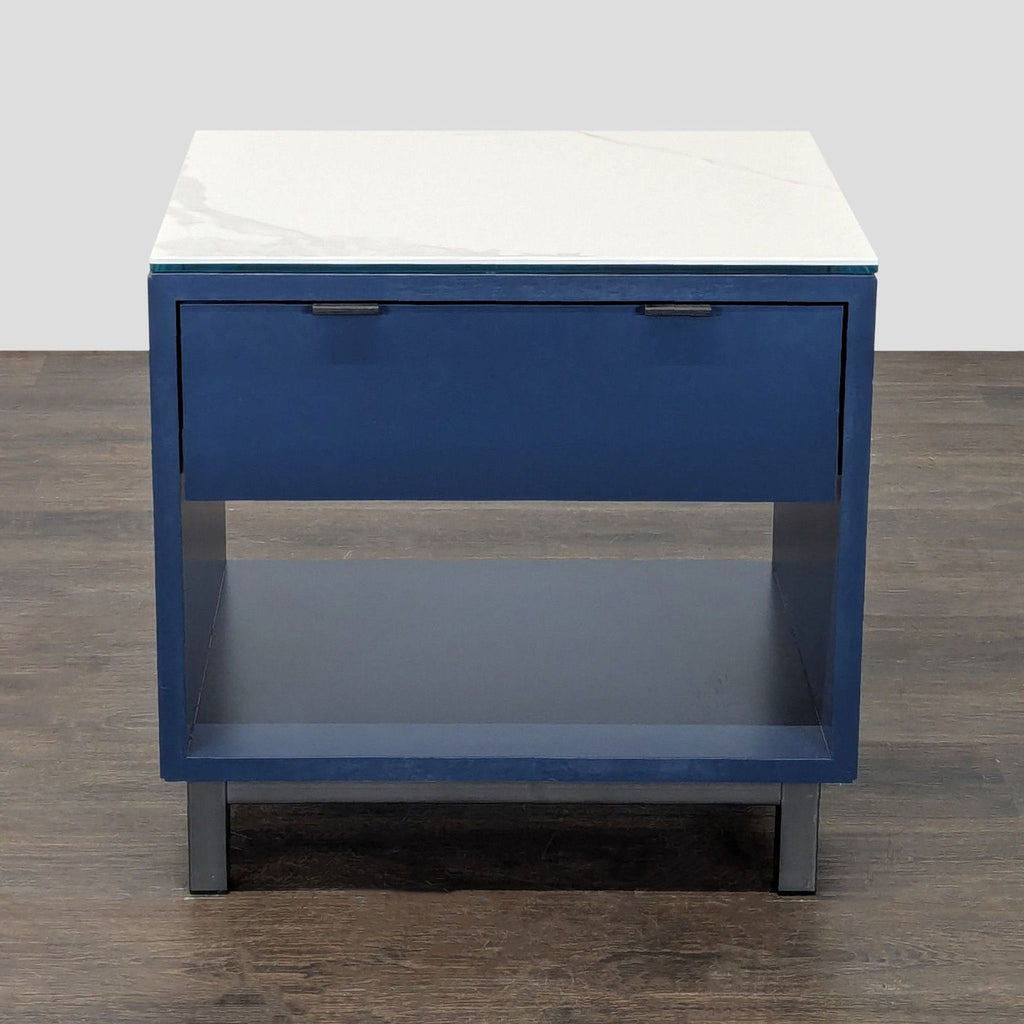 Room & Board nightstand in navy blue with open shelf, drawer, marbled ceramic top, and natural steel legs.