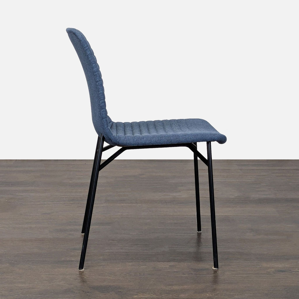 Modern dining chair featuring a curved seat, architectural steel base, and dark channel tufted fabric.  