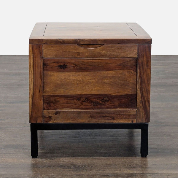 Crate and Barrel end table with natural wood top, black steel legs, and hidden lift-top storage.