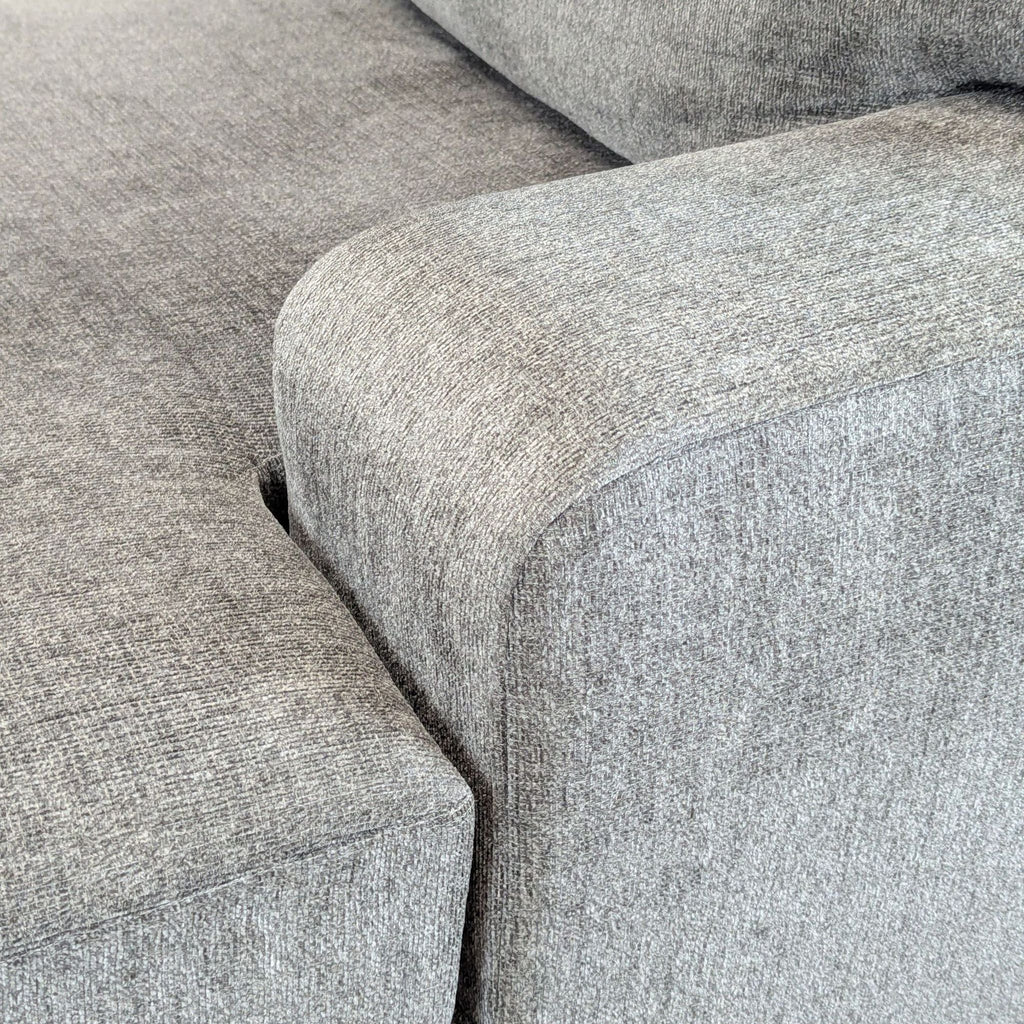 Ashley Furniture L-shaped sectional, upholstered in gray, includes a chaise and is ideal for gatherings.