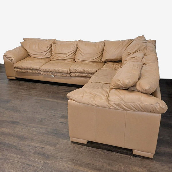 Tan leather sectional with plush cushions, ample seating, and sturdy frame; gently used and in good condition.