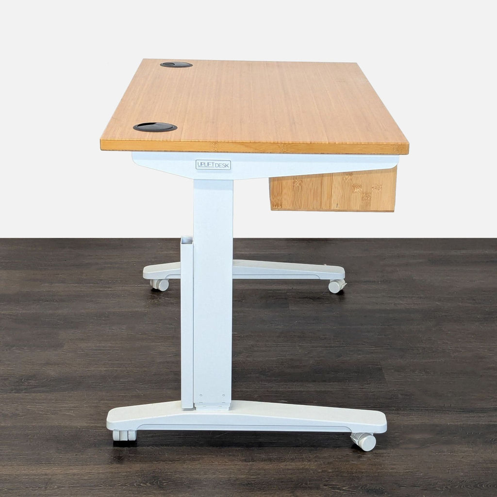 Uplift brand desk with electric height adjustment, natural bamboo surface, integrated storage, and organized cable management.