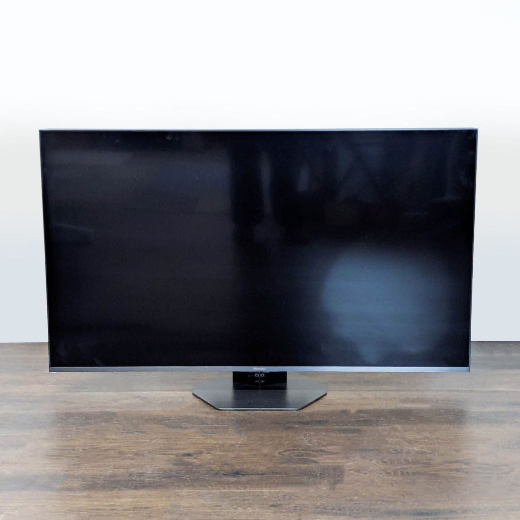 Hisense 55-inch TV with built-in Google TV, sleek design, and sturdy stand, ideal for home entertainment.
