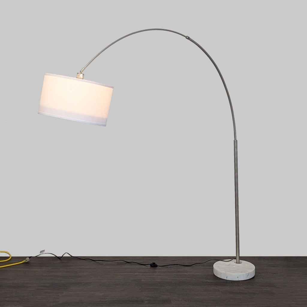 Modern arc floor lamp with a white fabric shade, sleek metal frame, and round marble base for stylish lighting.