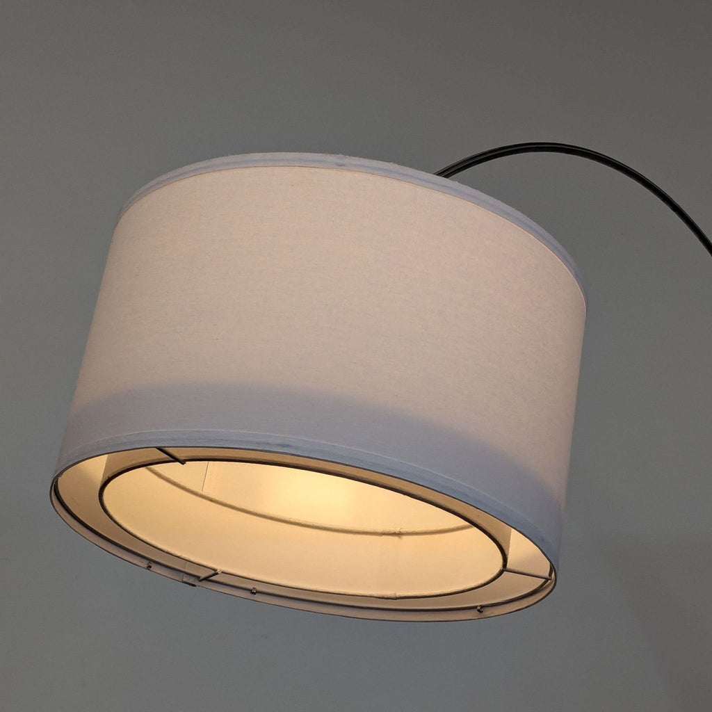 Contemporary floor lamp featuring an arched design, sturdy marble base, and large white shade for soft illumination.
