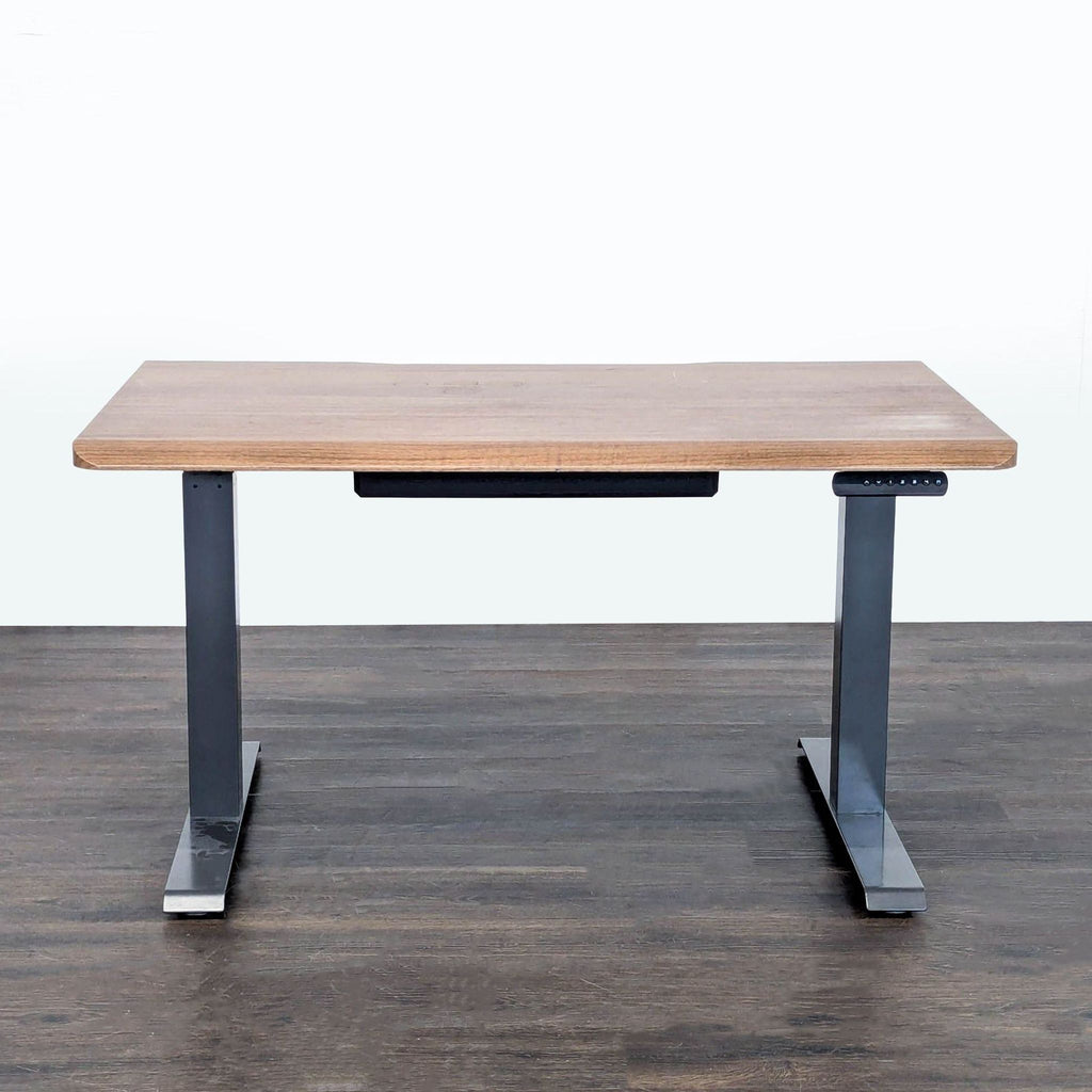 Sturdy Vari desk with a wood-look top and metal legs, featuring electronic height adjustment for sitting or standing.