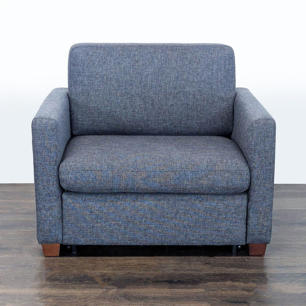 Dark gray Living Spaces sleeper chair with compact design, easily converts from armchair to guest bed.