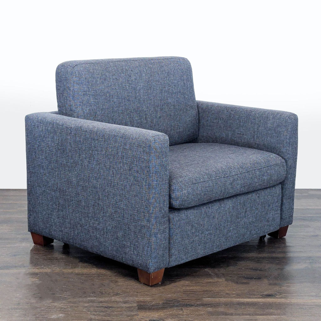 Multifunctional sleeper chair by Living Spaces, features modern dark gray upholstery and pull-out bed option.